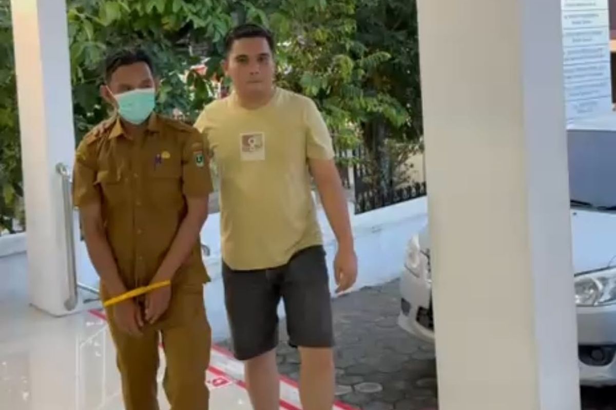 Foto: Oknum PNS Samsat Kota Solok HG (48) digiring petugas Satreskrim Polres Solok Kota usai ditetapkan sebagai tersangka dugaan penggelapan uang pajak kendaraan